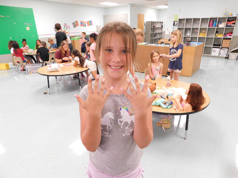 A smiling student in the school-age room at Monarch Children's Academy in East Orlando